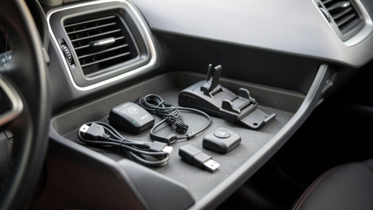 Photographie réaliste en gros plan du tableau de bord et du compartiment de la voiture, avec des accessoires amovibles disposés de manière ordonnée, lumière naturelle et ambiance d’inspection.